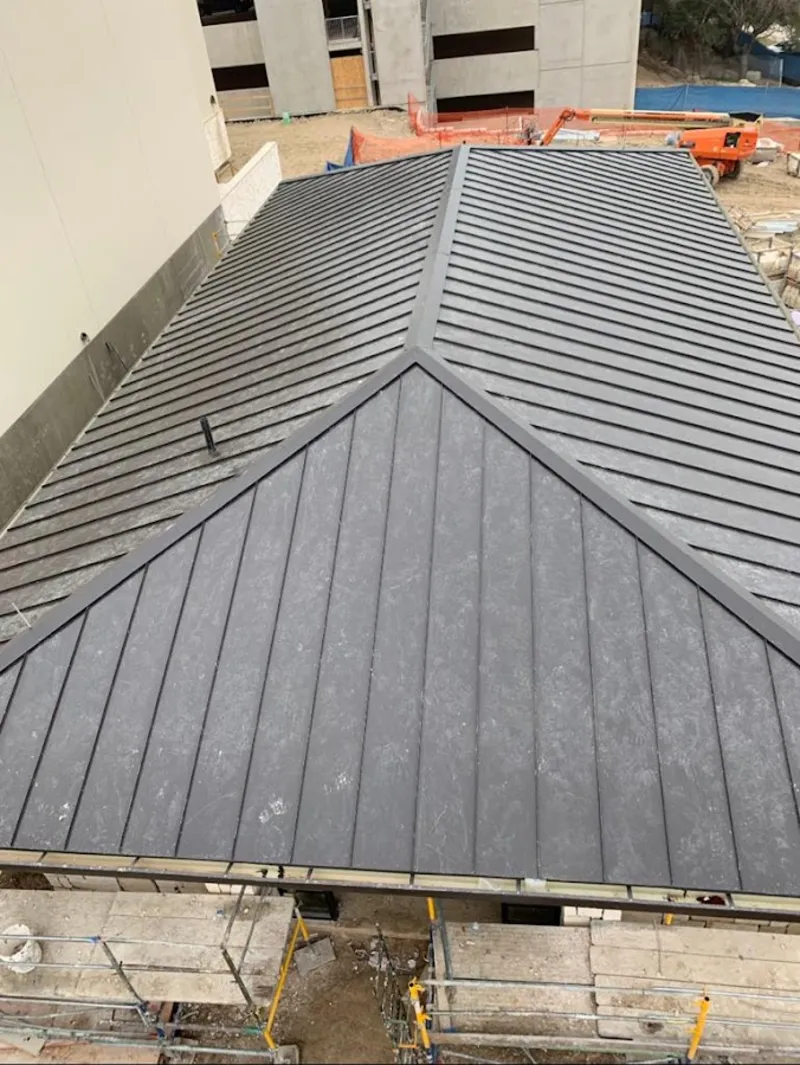 Commercial metal roof construction with crane equipment in Utica